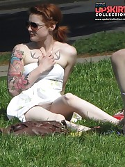 Tattooed redhead voyeured in a park. Sexy upskirt