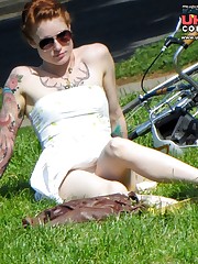Tattooed redhead voyeured in a park. Sexy upskirt up skirt pic