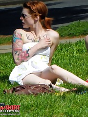 Tattooed redhead voyeured in a park. Sexy upskirt upskirt pussy